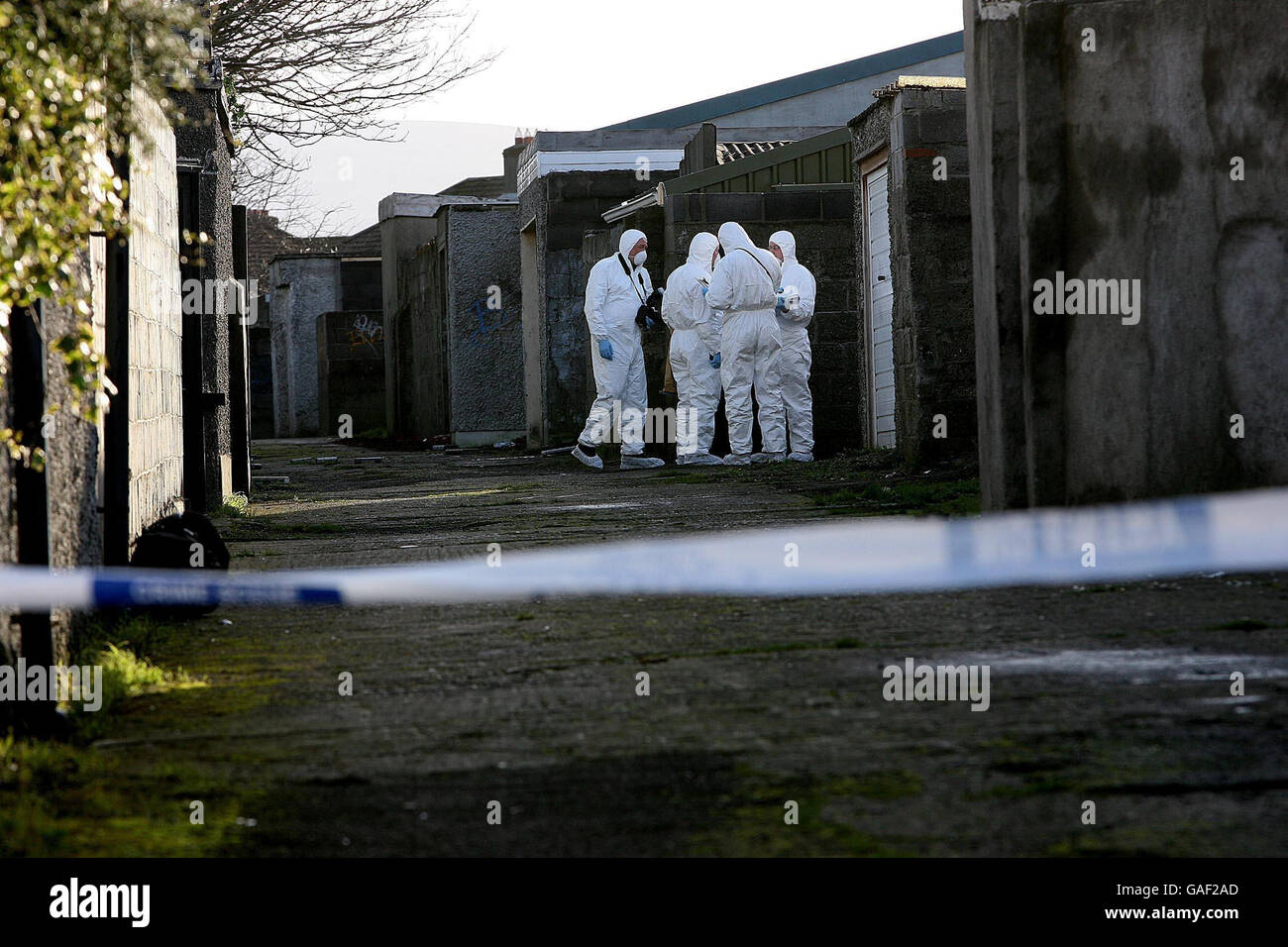 Forensische Gardai-Offiziere am Tatort des tödlichen Stichs in einem Durchgang an der Beechfield Road im Walkinstown-Viertel von Dublin. Stockfoto