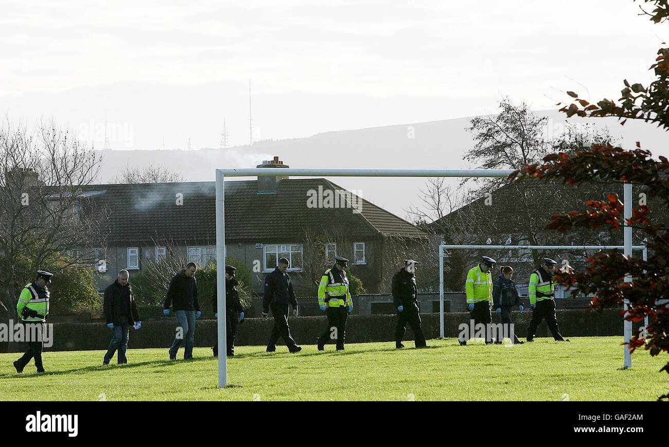 Gardai-Offiziere suchen ein Feld in der Nähe der tödlichen Stiche von gestern Abend in einem Abgang an der Beechfield Road im Viertel Walkinstown in Dublin. Stockfoto