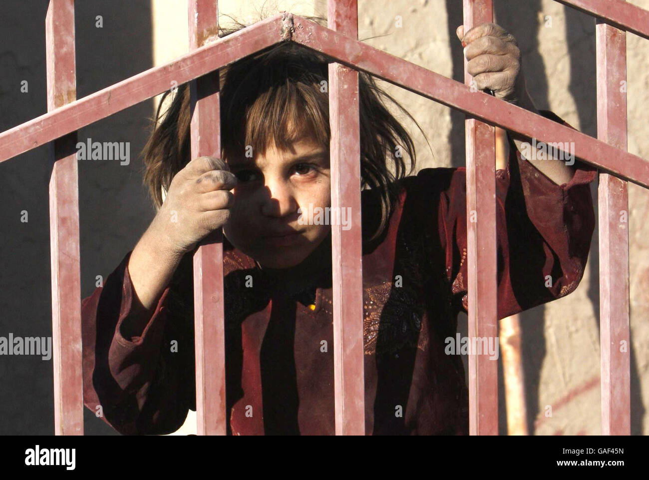 Ein Kind schaut durch den Zaun einer neuen Schule in Lashkar Gah, Afghanistan, eines von mehreren neuen Hilfsprojekten, die von der britischen Regierung finanziert werden. Stockfoto