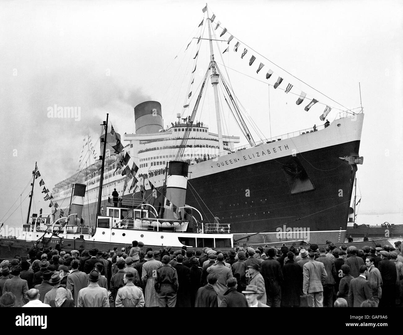 Genau um zwei Uhr fuhr die 83,000 Tonnen schwere Cunard-White Star Liner 'Queen Elizabeth' von ihren Anlegeplätzen in Southampton ab und rutschte langsam aus ihrem Liegeplatz, um ihre Jungfernfahrt nach New York zu beginnen. Stockfoto