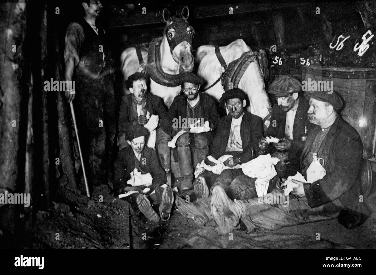 Kohlebergarbeiter, die eine Pause zum Essen machen, beobachtet von einigen der Grube-Ponys. Stockfoto