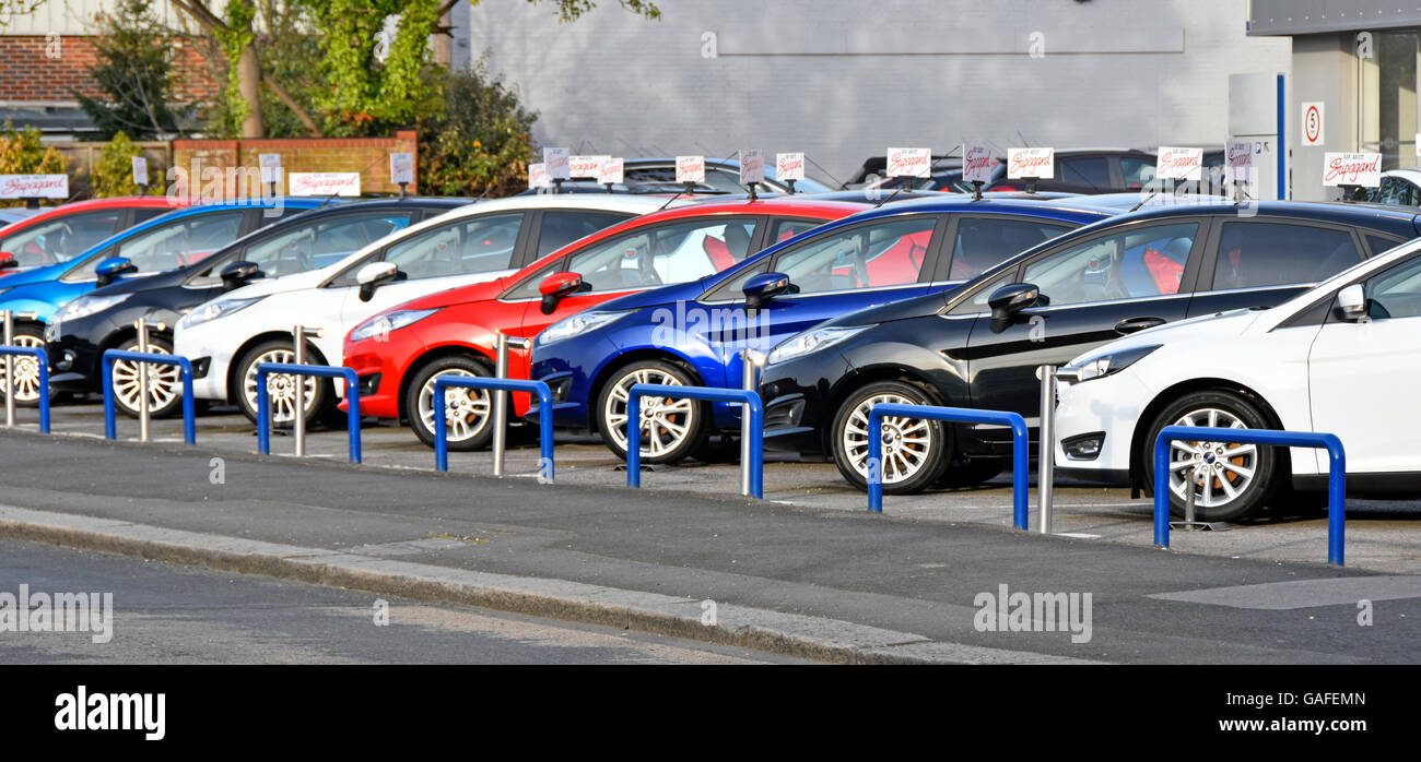 Ausstellung von Gebrauchtwagen durch den Autohändler zum Verkauf auf dem Straßenbahnvorplatz des Ford-Händlerbetriebs vor dem Ausstellungsraum Brentwood Essex England UK Stockfoto