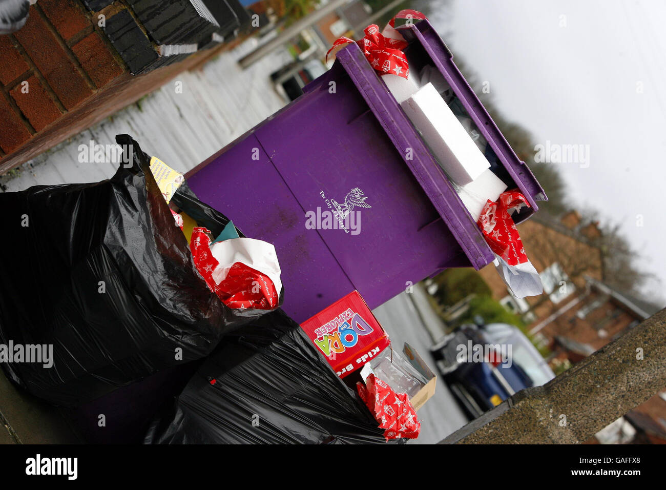 Eine Mülltonne in Liverpool überläuft mit Geschenkpapier und Verpackungen aus geöffneten Weihnachtsgeschenken. Stockfoto