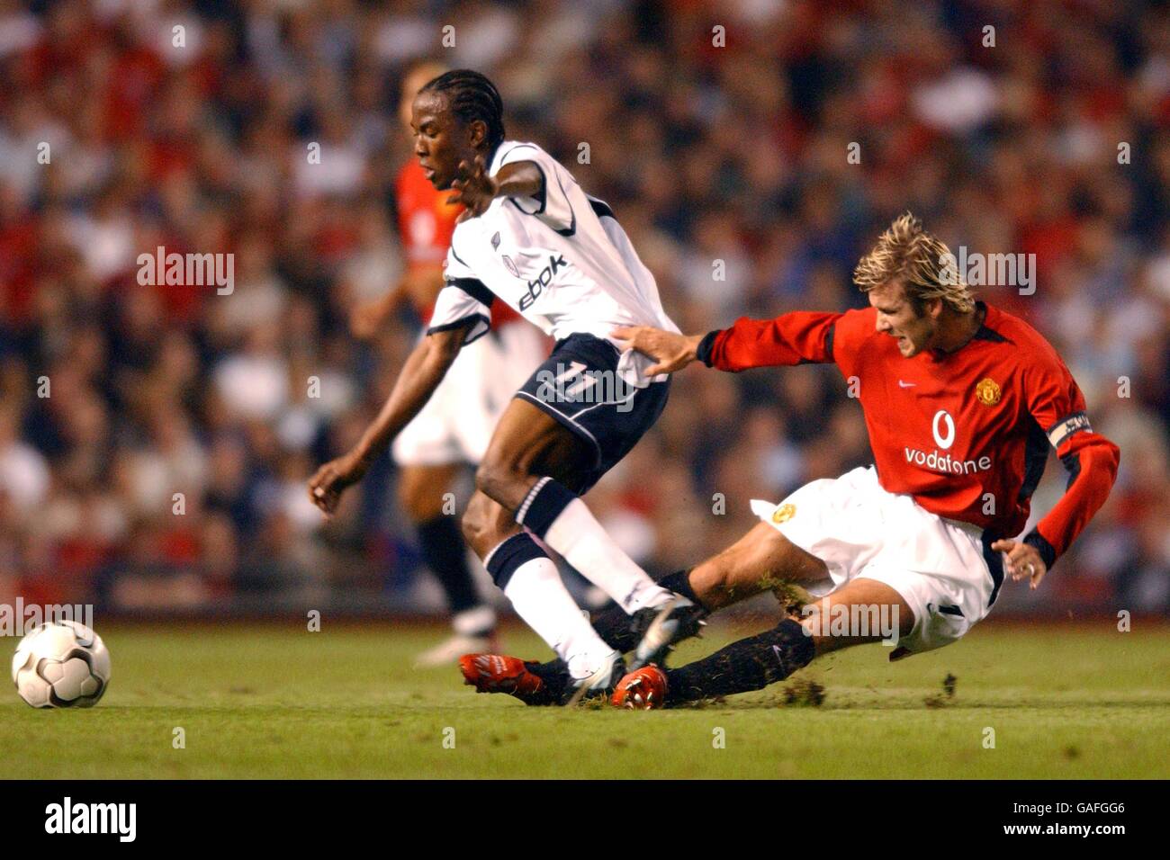 Fußball - FA Barclaycard Premiership - Manchester United / Bolton Wanderers. Ricardo Gardner von Bolton Wanderers kämpft mit David Beckham von Manchester United um den Ball Stockfoto