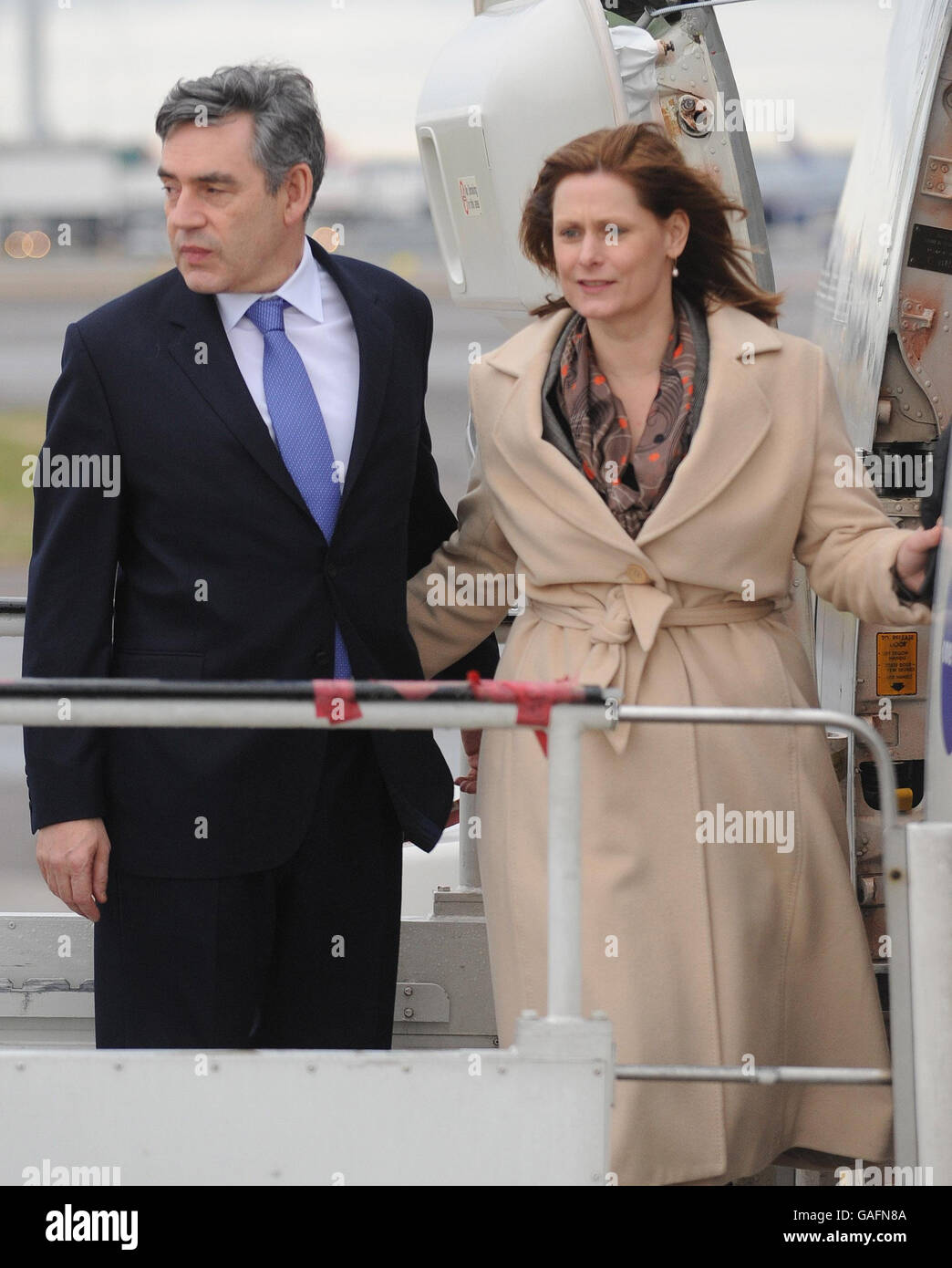 Der britische Premierminister Gordon Brown und seine Frau Sarah steigen heute am Flughafen Heathrow in sein Flugzeug ein, das nach China geht. Ein Boeing 777-Flugzeug von British Airways, das aus China hereinfliegt und kurz vor der Start- und Landebahn am Flughafen Heathrow landete, um das Flugzeug des Premierministers zu verzögern. Stockfoto