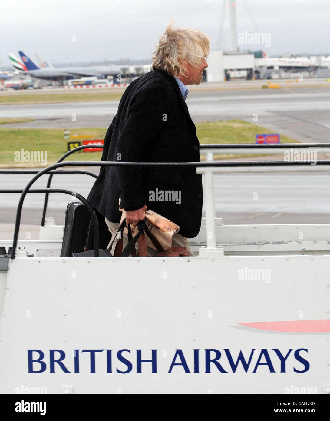 Sir Richard Branson besteigen ein Flugzeug von British Airways, um mit dem britischen Premierminister Gordon Brown als Teil einer Geschäftsdelegation nach China zu reisen. Ein Boeing 777-Flugzeug von British Airways, das aus China einfliegt und kurz vor der Start- und Landebahn am Flughafen Heathrow landete, um das Flugzeug des Premierministers zu verzögern. Stockfoto