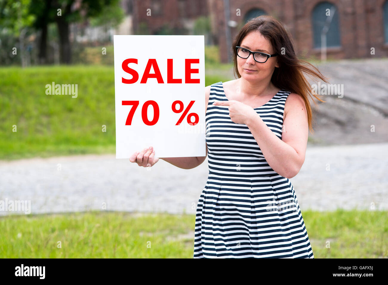 ein Bild von einer Frau mit einem Verkaufsschild in der hand Stockfoto