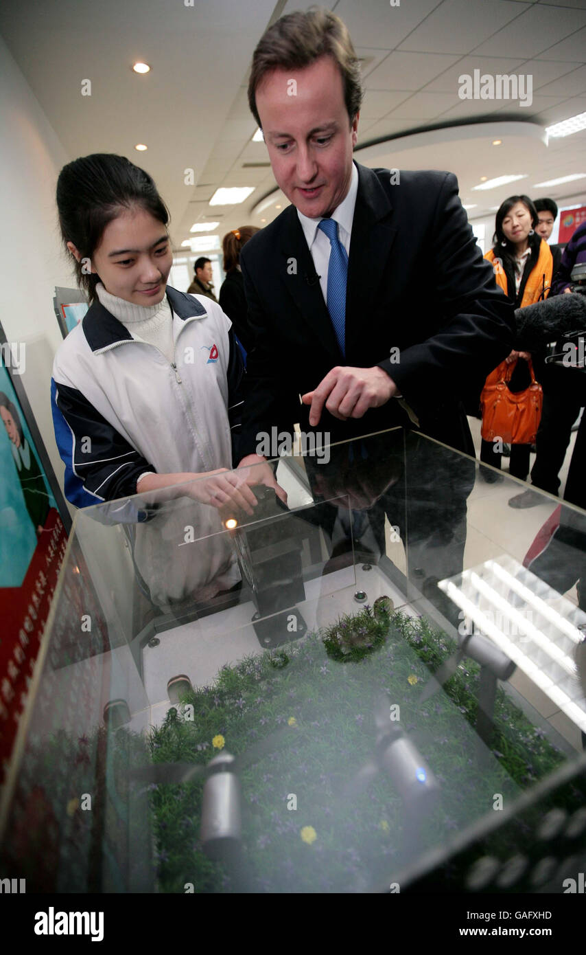 Der Vorsitzende der Konservativen Partei David Cameron nimmt am zweiten Tag einer dreitägigen Tour durch das Land an einem Wissenschaftsexperiment mit einem Schüler an der Dongzhimen Mittelschule in Peking in China Teil. Stockfoto