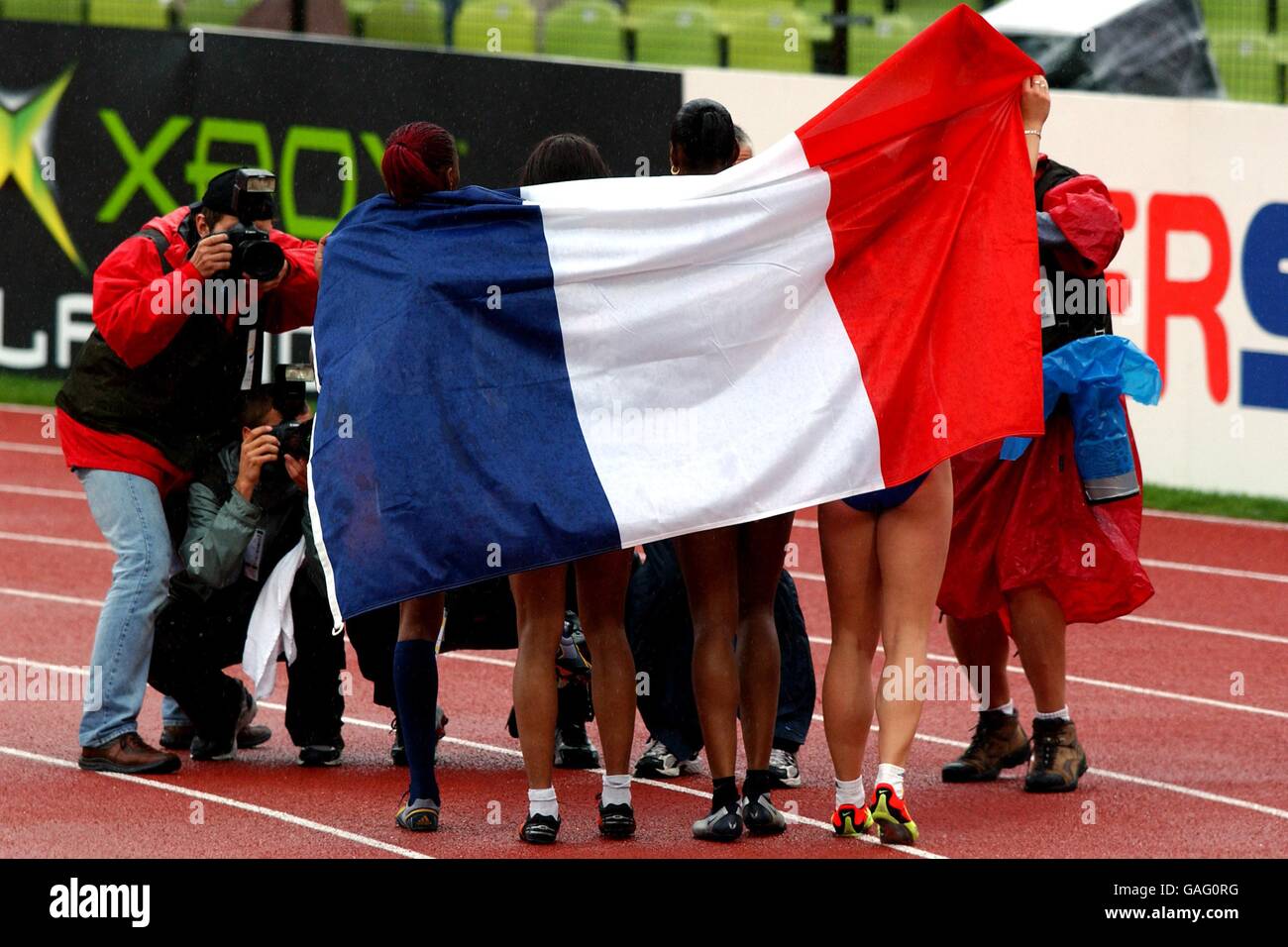 Frankreichs 4x100-m-Staffel posiert für Fotografen, die mit ihrer Nationalflagge drapiert sind, nachdem sie Gold gewonnen haben Stockfoto