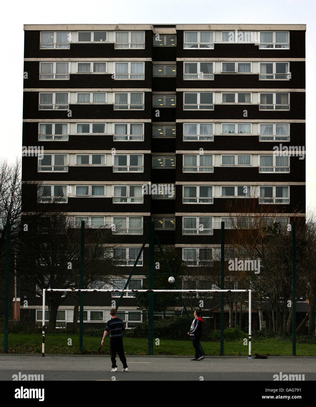 Teenager spielen Fußball auf dem Sportplatz auf Heath Town Estate in Wolverhampton Stockfoto