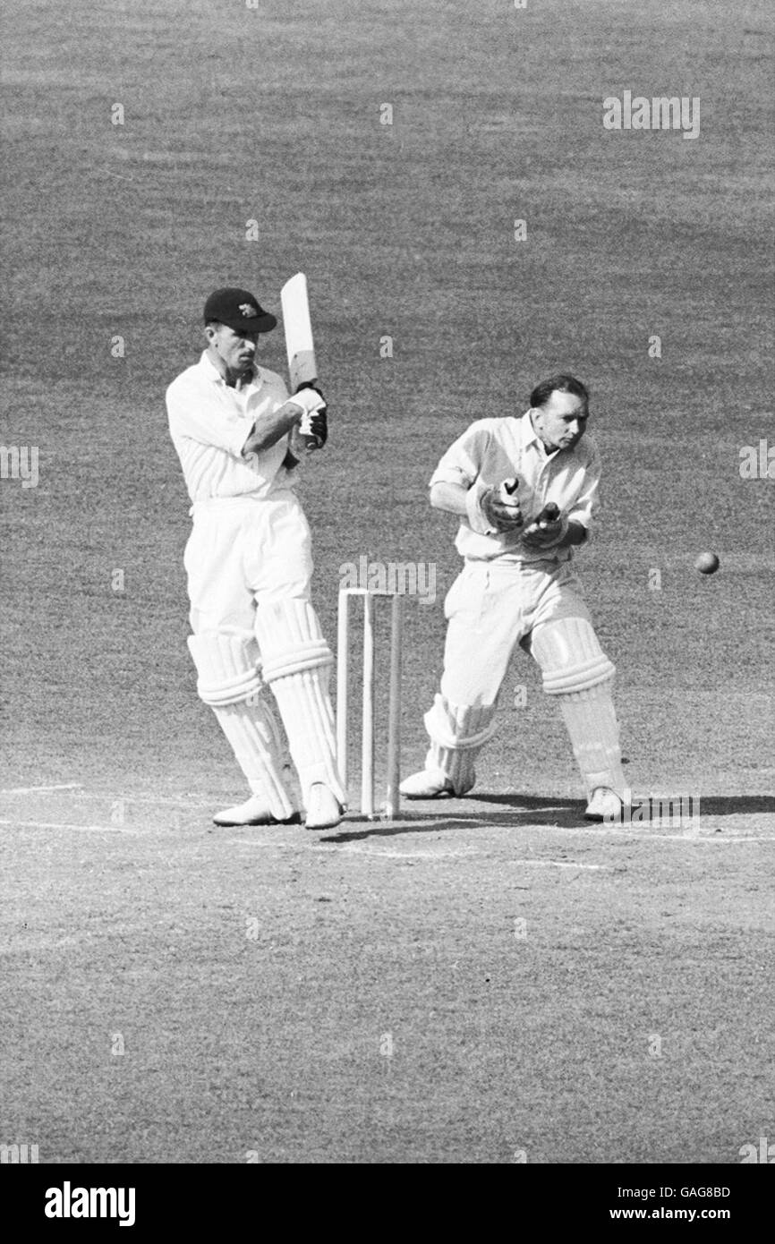 Middlesex's Jack Robertson (l) dreht einen Ball von Surreys Jim Laker (aus dem Bild) zu den Rutschen, beobachtet von Surrey Wicketkeeper Arthur McIntyre (2. L) Stockfoto