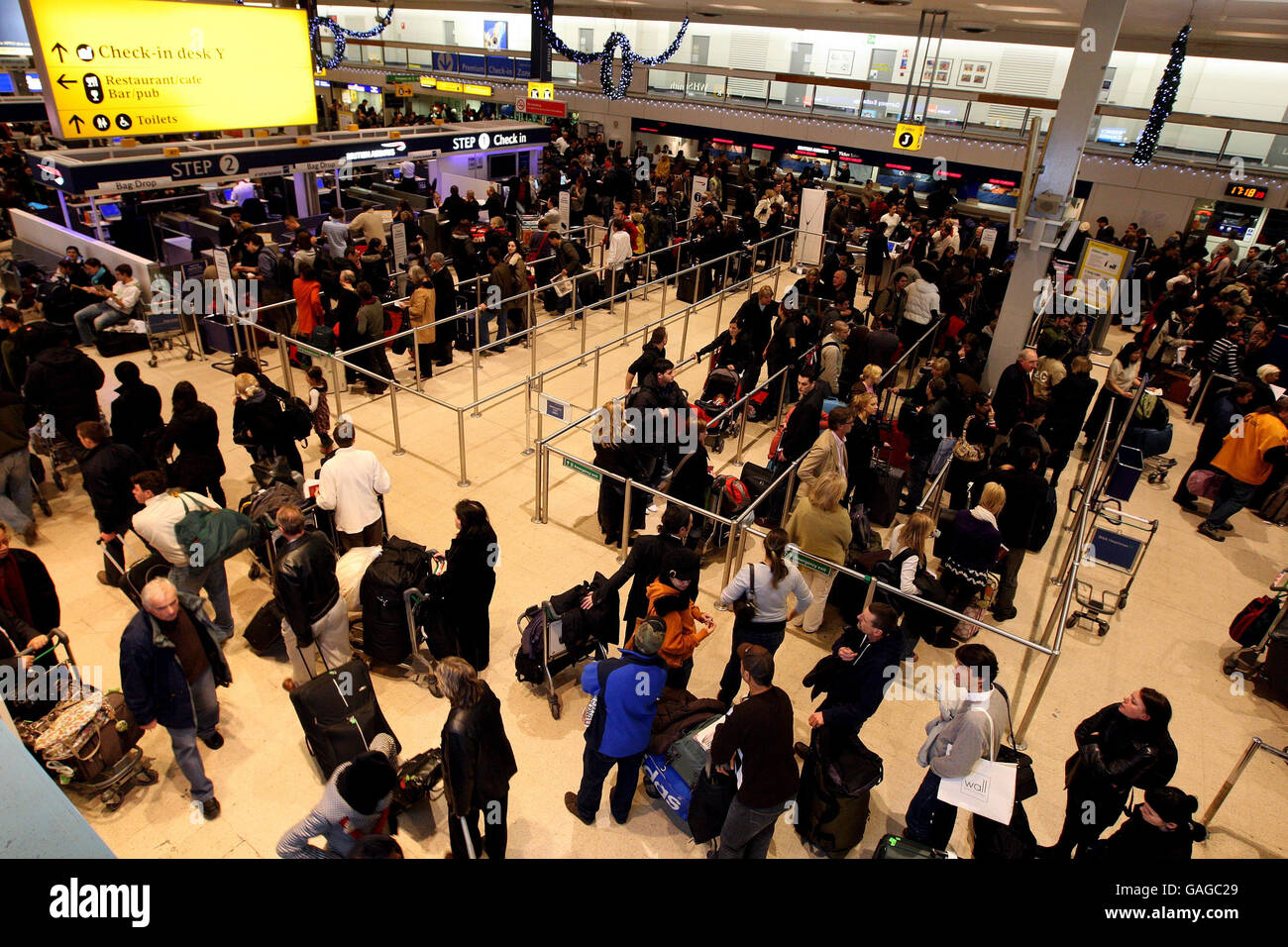 Passagiere Schlange im Terminal 1 des Flughafens Heathrow nach dichtem Nebel verursacht zahlreiche Flugausfälle. Stockfoto