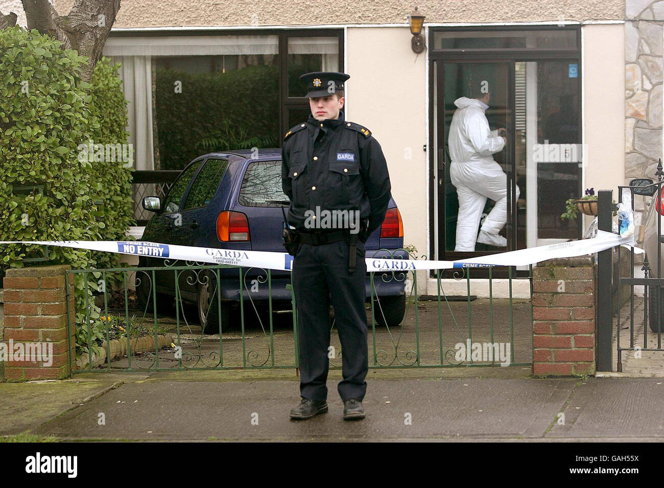Mann nach bewaffnetem Raub festgehalten. Gardai-Offiziere durchsuchen in Dublin, Irland, ein Familienhaus, in dem ein versuchten Raub stattfand. Stockfoto