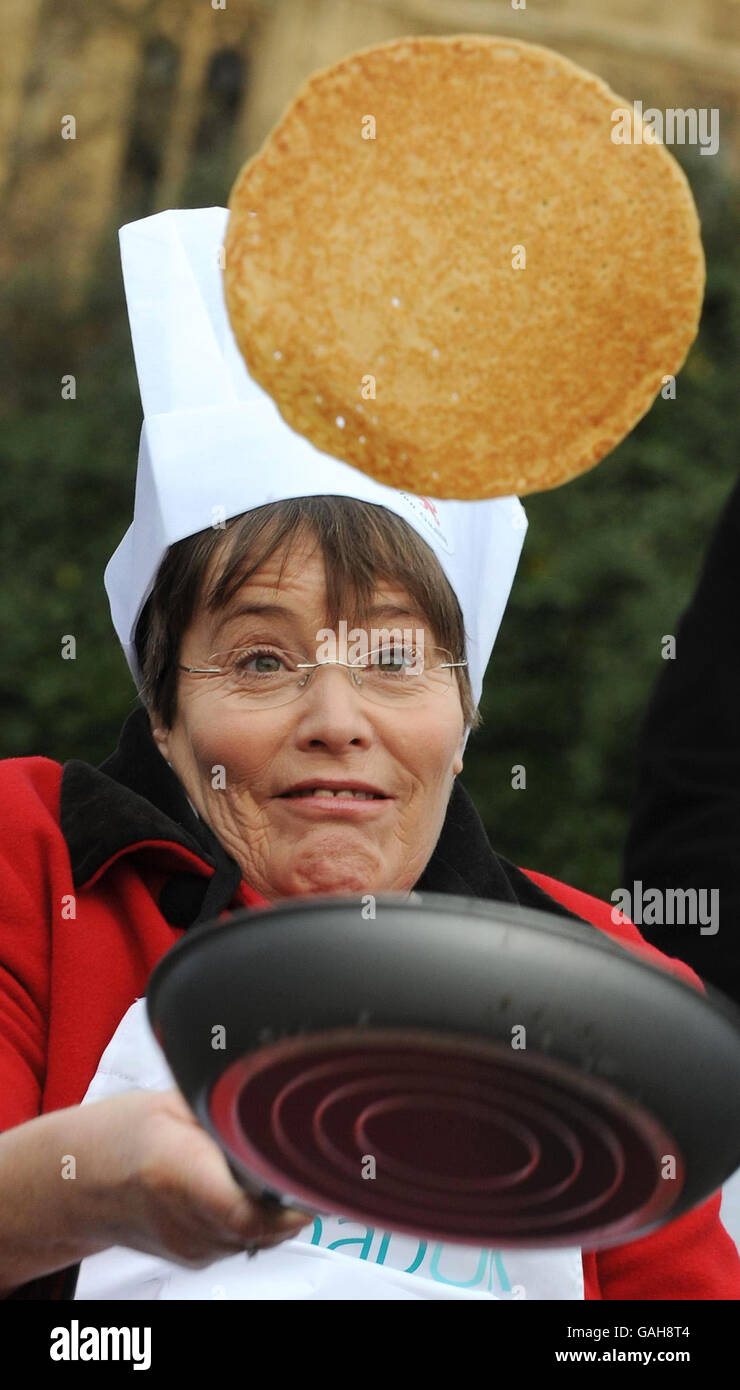 Anne Begg, MP, übt ihren Pfannkuchen, der vor dem Londoner Parlamentsgebäude geworfen wird, bevor sie am Parliamentary Pancake Race teilnimmt. Stockfoto