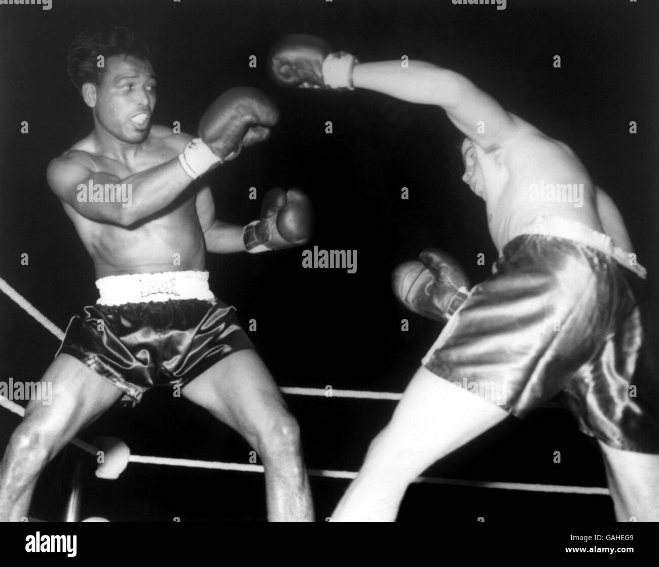 Der 42-jährige ehemalige Weltmeister im Mittelgewicht, Sugar Ray Robinson (l), verblüfft Terry Downes (r) in der ersten Runde ihres Kampfes Stockfoto