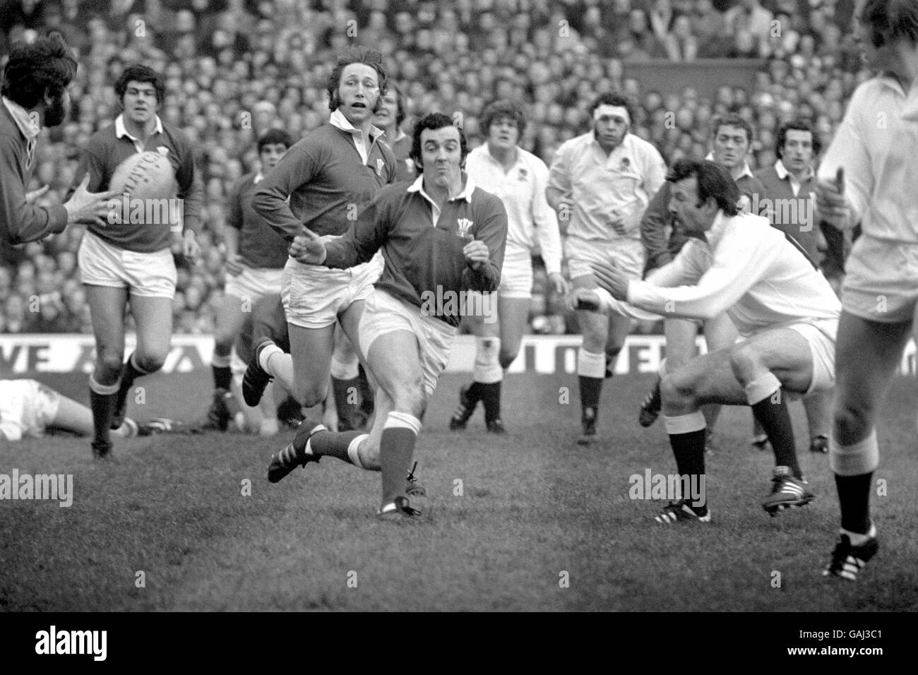 Rugby Union - Five Nations Championship - England gegen Wales. Phil Bennett aus Wales (c, r) gibt den Ball an den Flügel, beobachtet von Teamkollege JPR Williams (c, l) Stockfoto