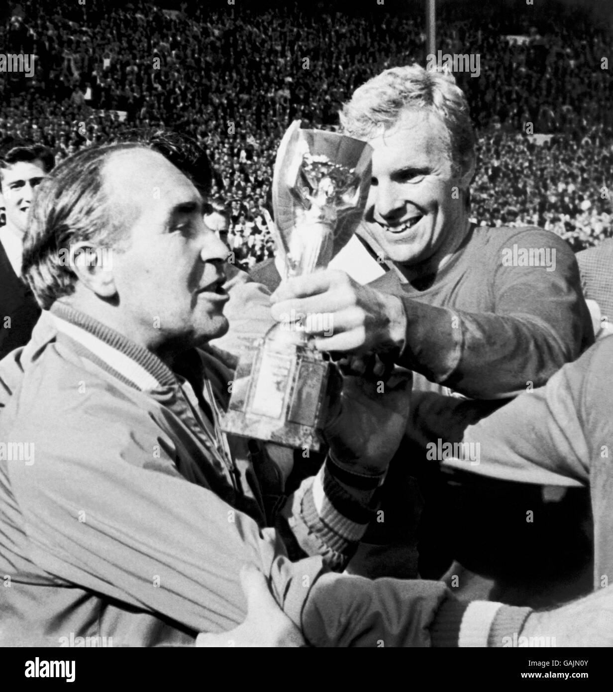 England gegen Westdeutschland - Weltcup-Finale 1966 - Wembley-Stadion. Der jubelende englische Kapitän Bobby Moore (r) zeigt nach dem Sieg über 4-2 die Jules Rimet-Trophäe an Manager Alf Ramsey (l). Stockfoto