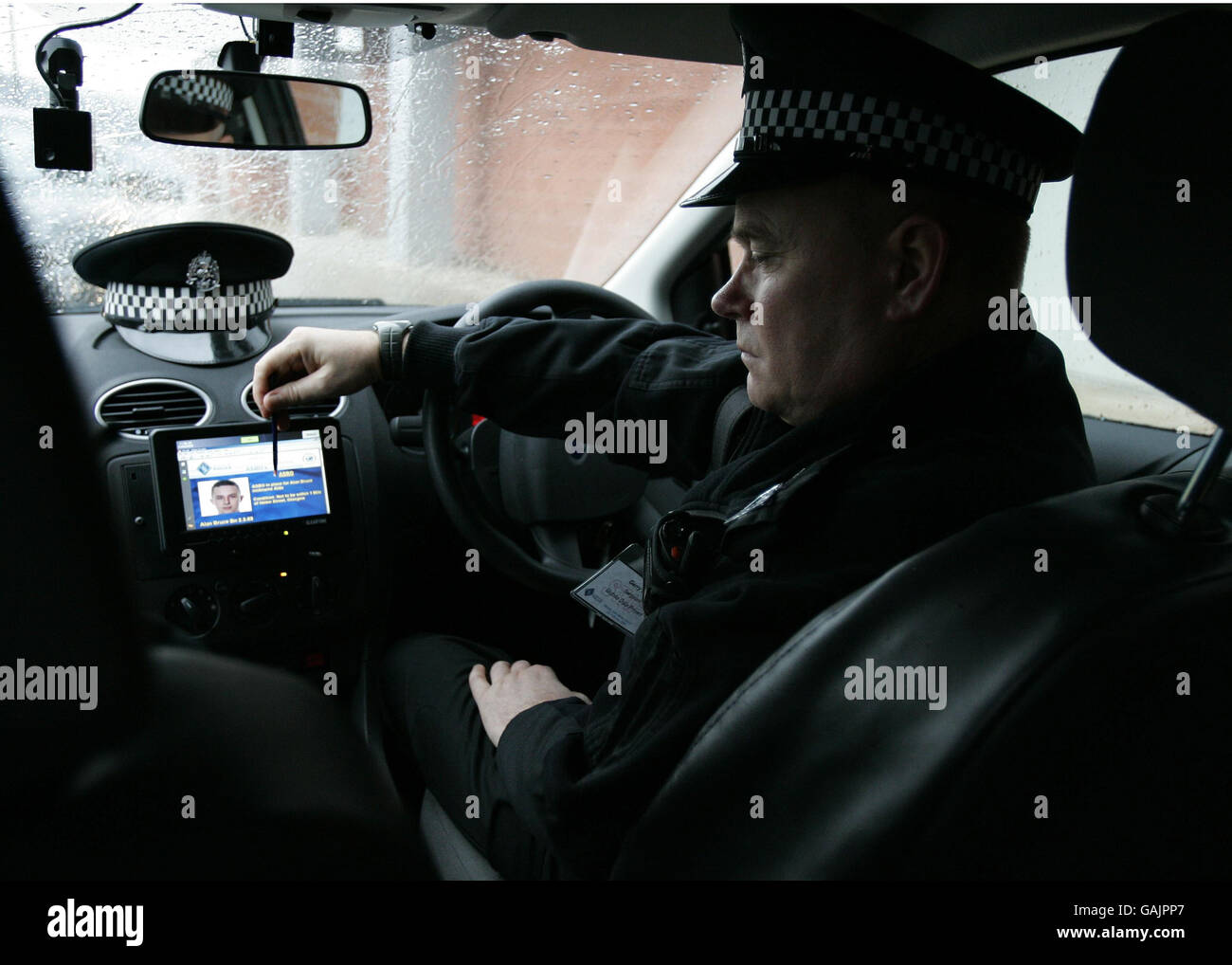Ein Strathclyde Polizist mit einem neuen integrierten Computersystem, das auch als Notebook auf dem Beat verwendet werden kann und das auch in Patrouillenfahrzeugen eingebaut ist. Stockfoto