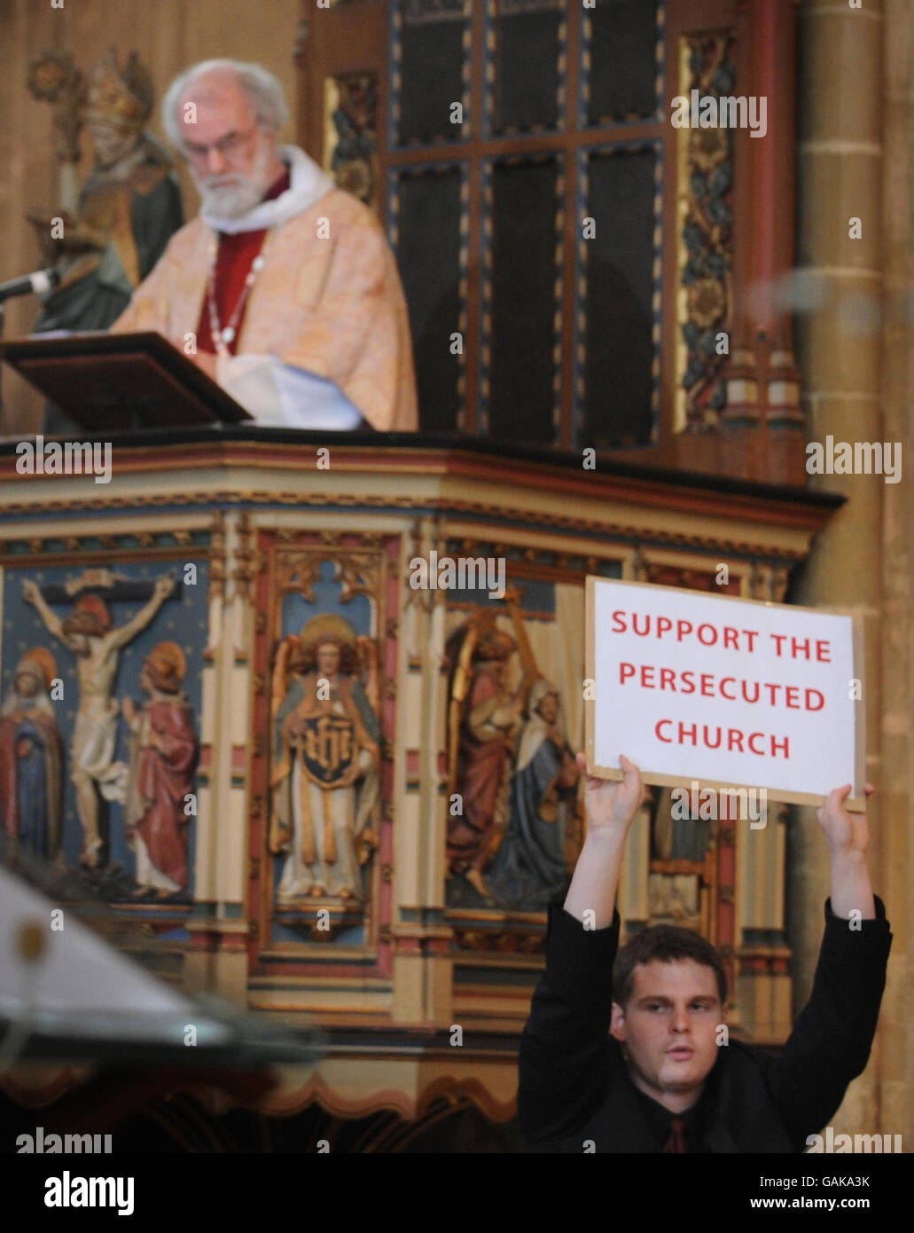 Der Erzbischof von Canterbury, Dr. Rowan Williams, wird von Demonstranten unterbrochen, als er heute in der Kathedrale von Canterbury in Kent seinen Osterdienst halten will. Stockfoto