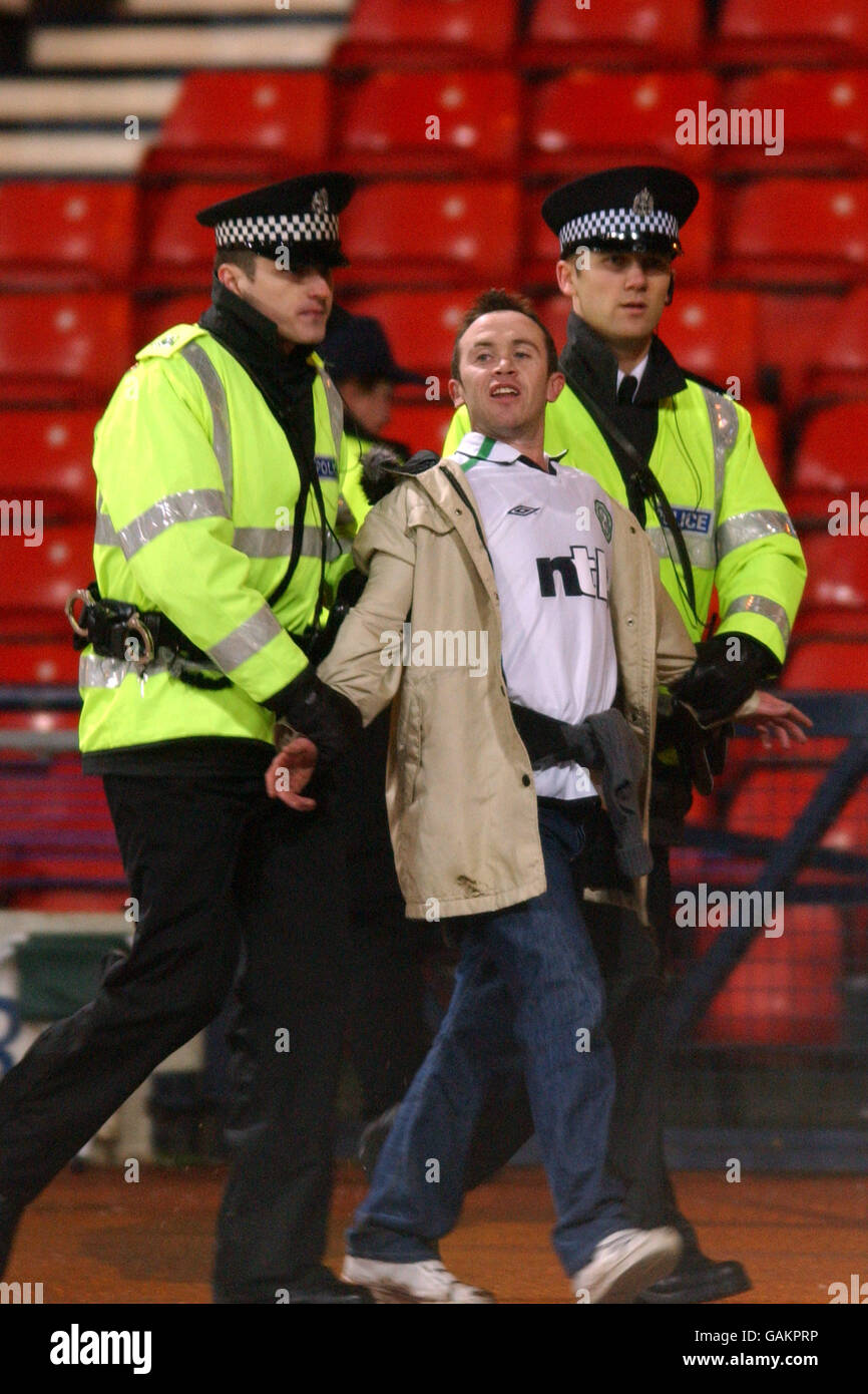 Fußball - CIS Insurance Cup - Halbfinale - Celtic / Dundee United. Ein keltischer Fan wird von zwei Polizisten begleitet Stockfoto