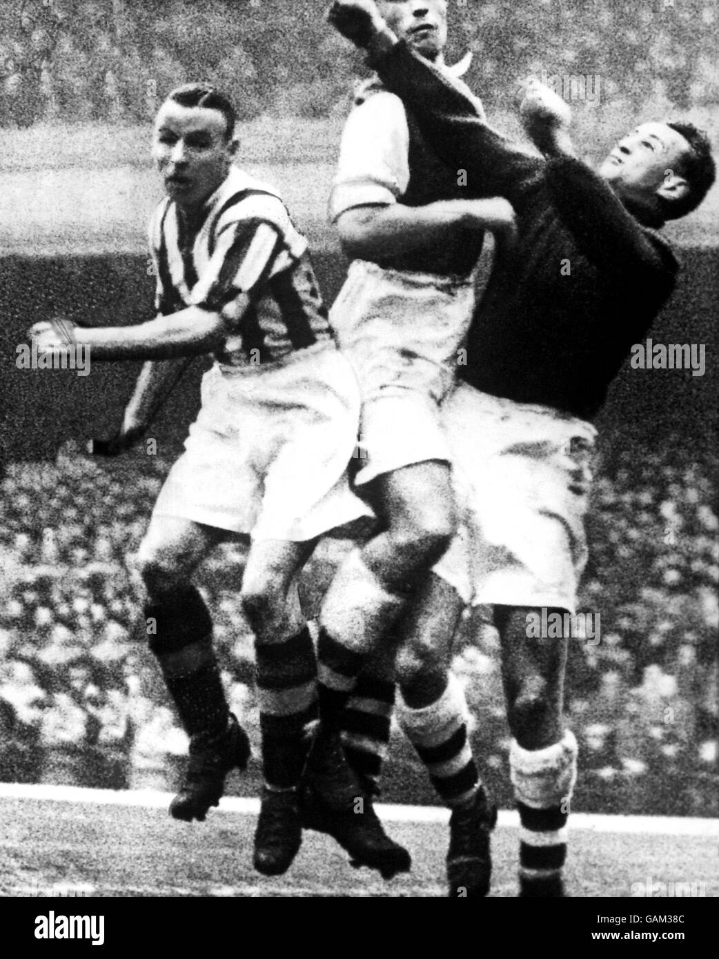 Arsenal-Torwart Alex Wilson (r) schlägt unter Druck aus Teamkollege Les Compton (c) und Stanley Matthews von Stoke City (l) Stockfoto