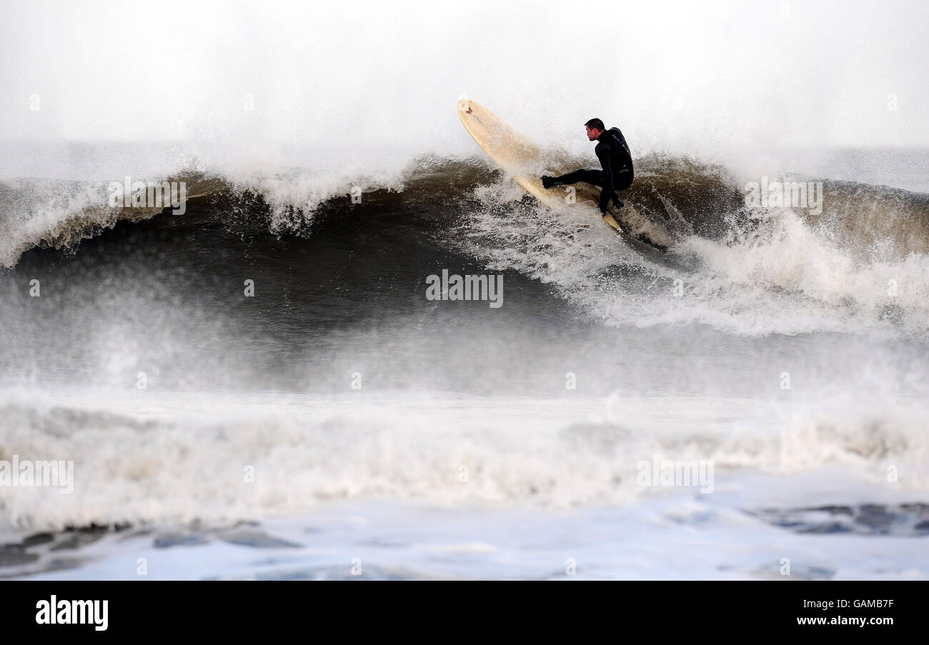 Starker Sturm vorhergesagt. Ein Surfer genießt die riesige Brandung in Tynemouth, da stürmische Winde für das Wochenende prognostiziert werden. Stockfoto
