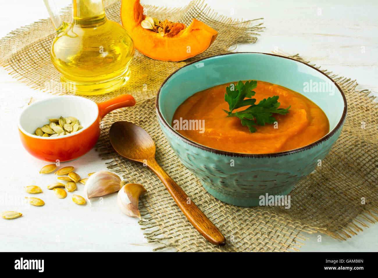 Würzig gebratene Kürbis Cremesuppe mit Petersilie in den Türkis Cup auf Sackleinen Stockfoto