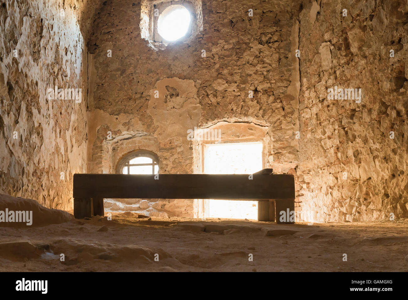 Alte hölzerne Bett im Inneren der alten Gefängniszelle auf Palamidi Burg in Nafplio Griechenland. Stockfoto