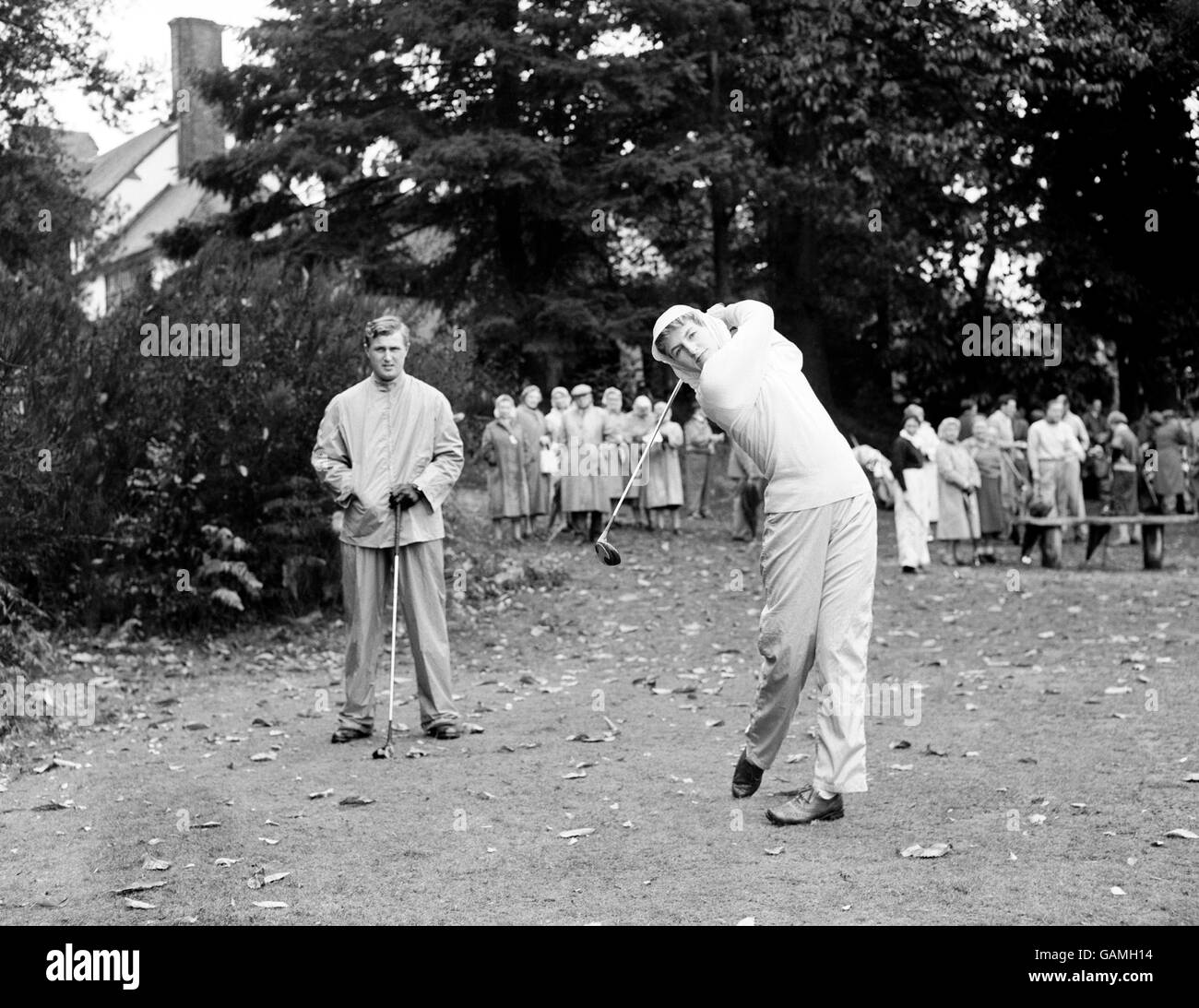 Golf - Mixed Scratch Foursomes - Worplesdon Golf Course - Surrey. Die Inhaberin des Mixed Scratch Foursome Frau M F Bonallack fährt, beobachtet von ihrem Mann Michael Bonallack. Stockfoto