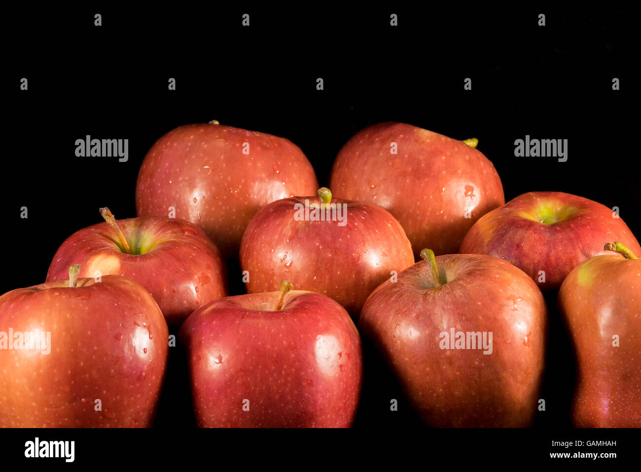 Saftige Äpfel mit Wassertropfen auf schwarzem Hintergrund. Stockfoto