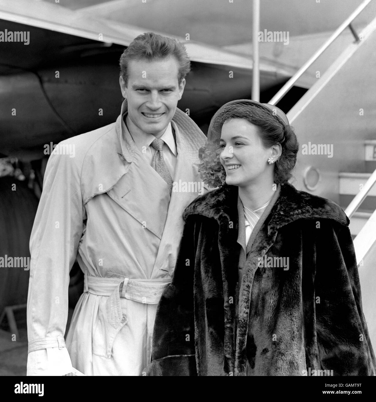 Charlton Heston, Star von Cecil de Milles 'The Greatest Show on Earth', fotografiert mit seiner 28-jährigen Schauspielerin Lydia Heston am Flughafen London. Stockfoto