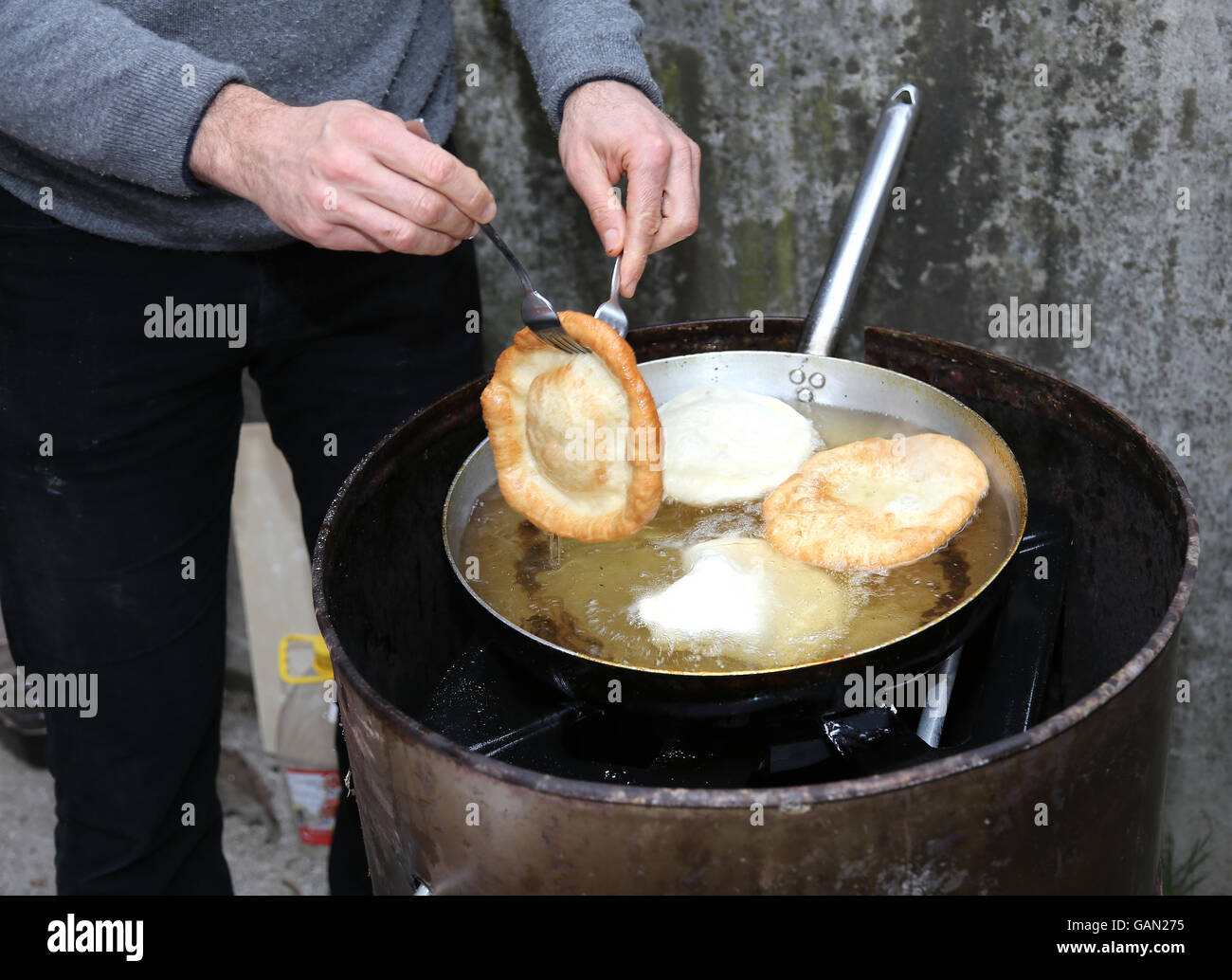 Cook Hände während der Vorbereitung der Krapfen in sehr heißem Öl Stockfoto