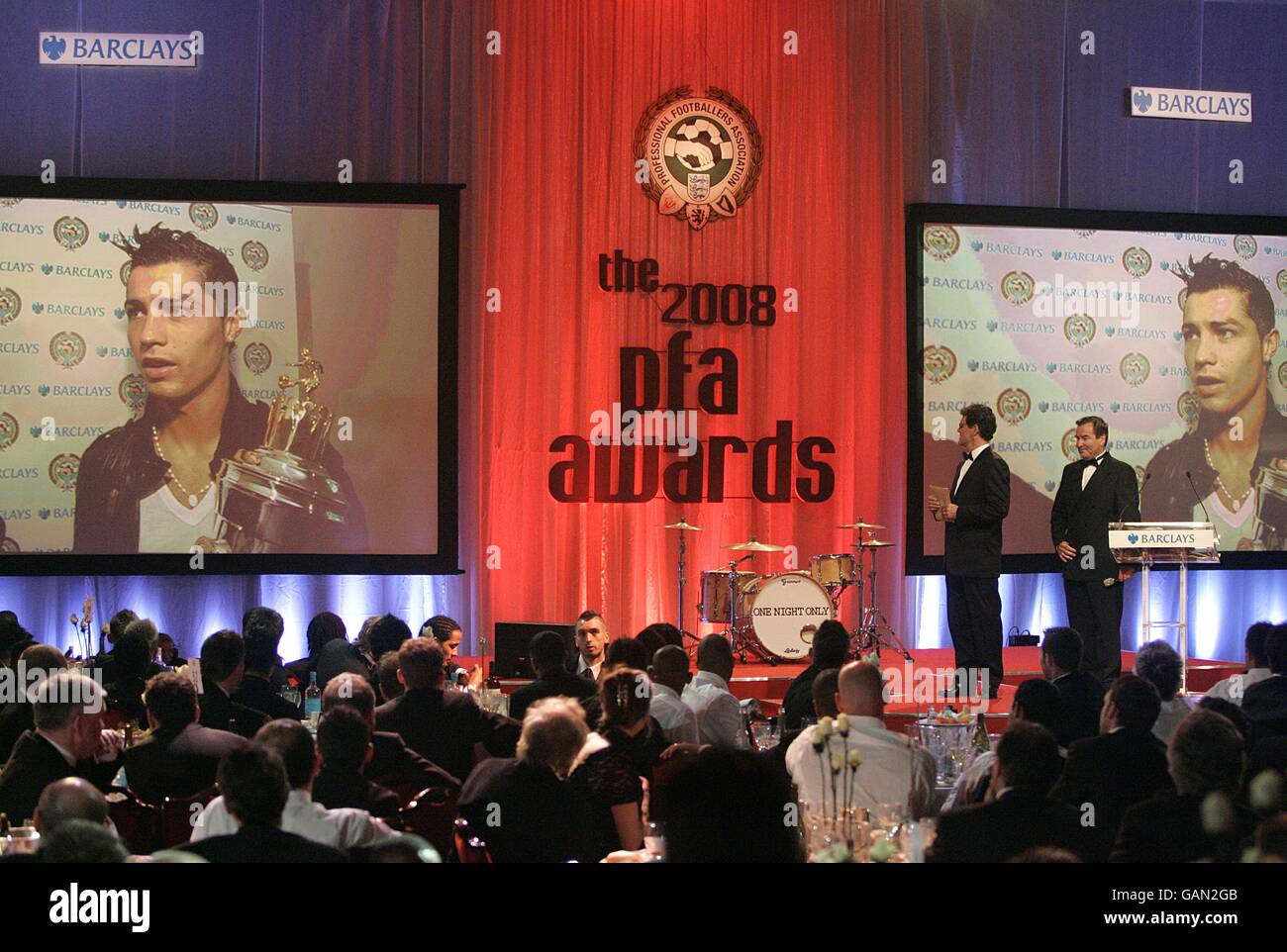 England Manager Fabio Capello und Jeff Stelling auf der Bühne als PFA Players Player of the Year Preisträger Cristiano Ronaldo hält eine Rede per Video bei den PFA Player of the Year Awards 2008 im Grosvenor House Hotel, London. Stockfoto