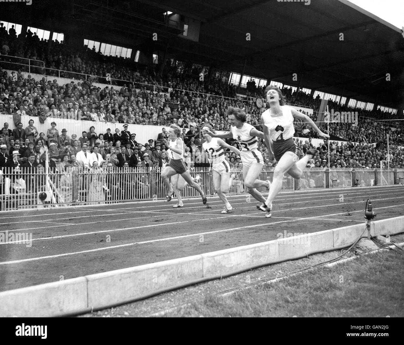 Die Australier Marlene Mathews (r) gewinnt Gold im 110-Yds-Finale der Frauen von Teamkollege Betty Cuthbert (l, 4.) und der britischen Heather Armitage (2. R, Silber) und Madelaine Weston (3. R, Bronze) Stockfoto