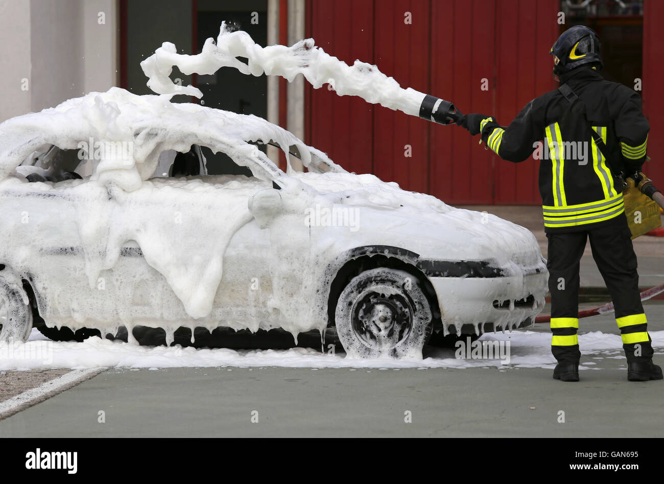 Feuerwehrleute während des Trainings, ein Feuer in einem Auto mit Schaum zu  löschen Stockfotografie - Alamy