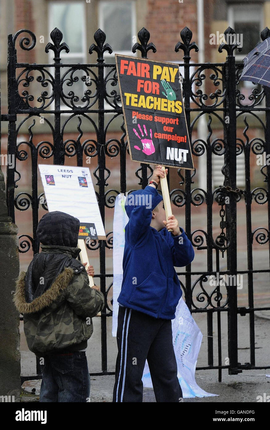 Junge Unterstützer, die Plakate halten, unterstützen den Streik der Nationalen Lehrergewerkschaft vor einer Schule in Leeds. Stockfoto