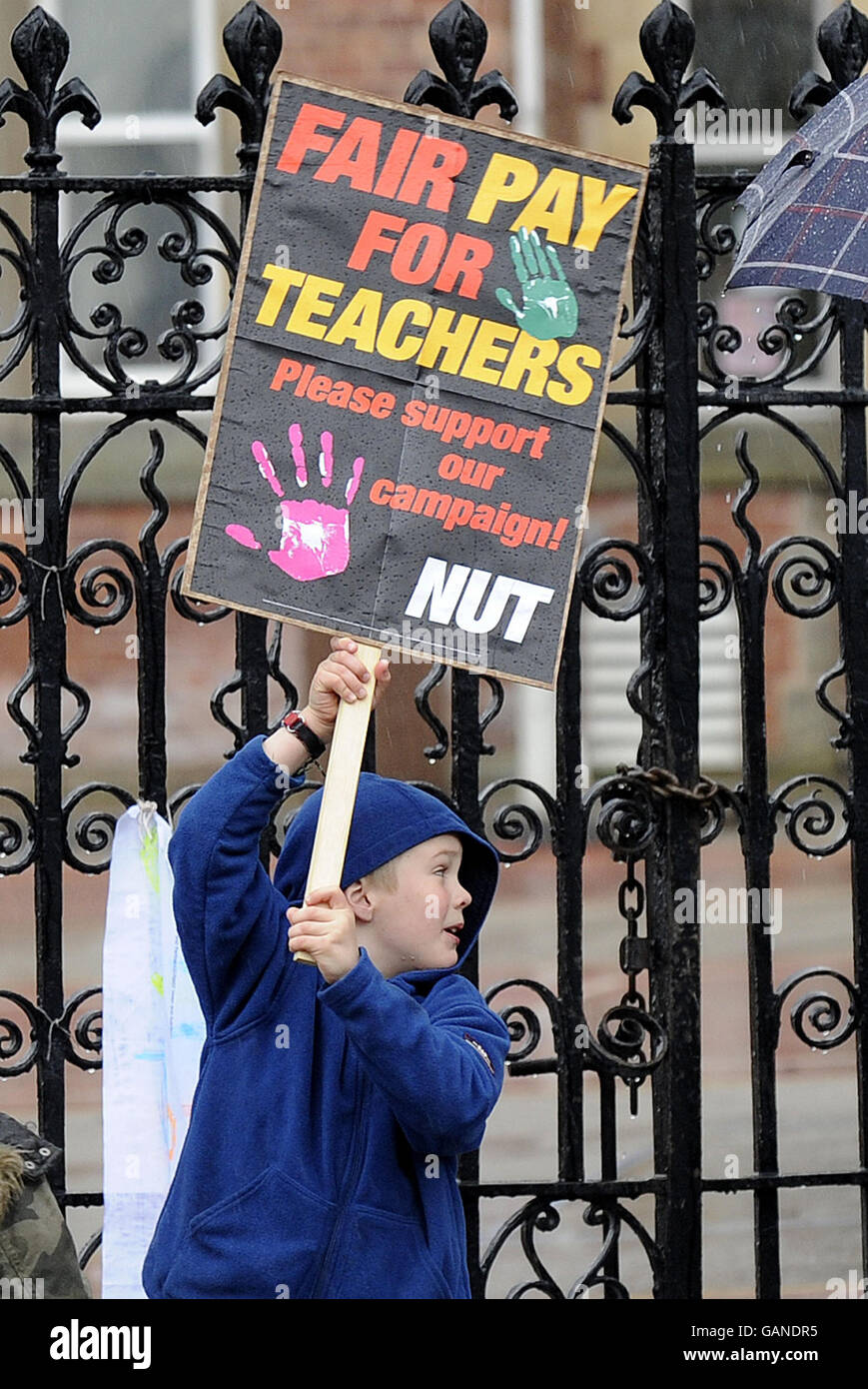 Lehrer streiken. Junge Anhänger halten Plakate, die den NUSSSTREIK vor einer Schule in Leeds unterstützen. Stockfoto