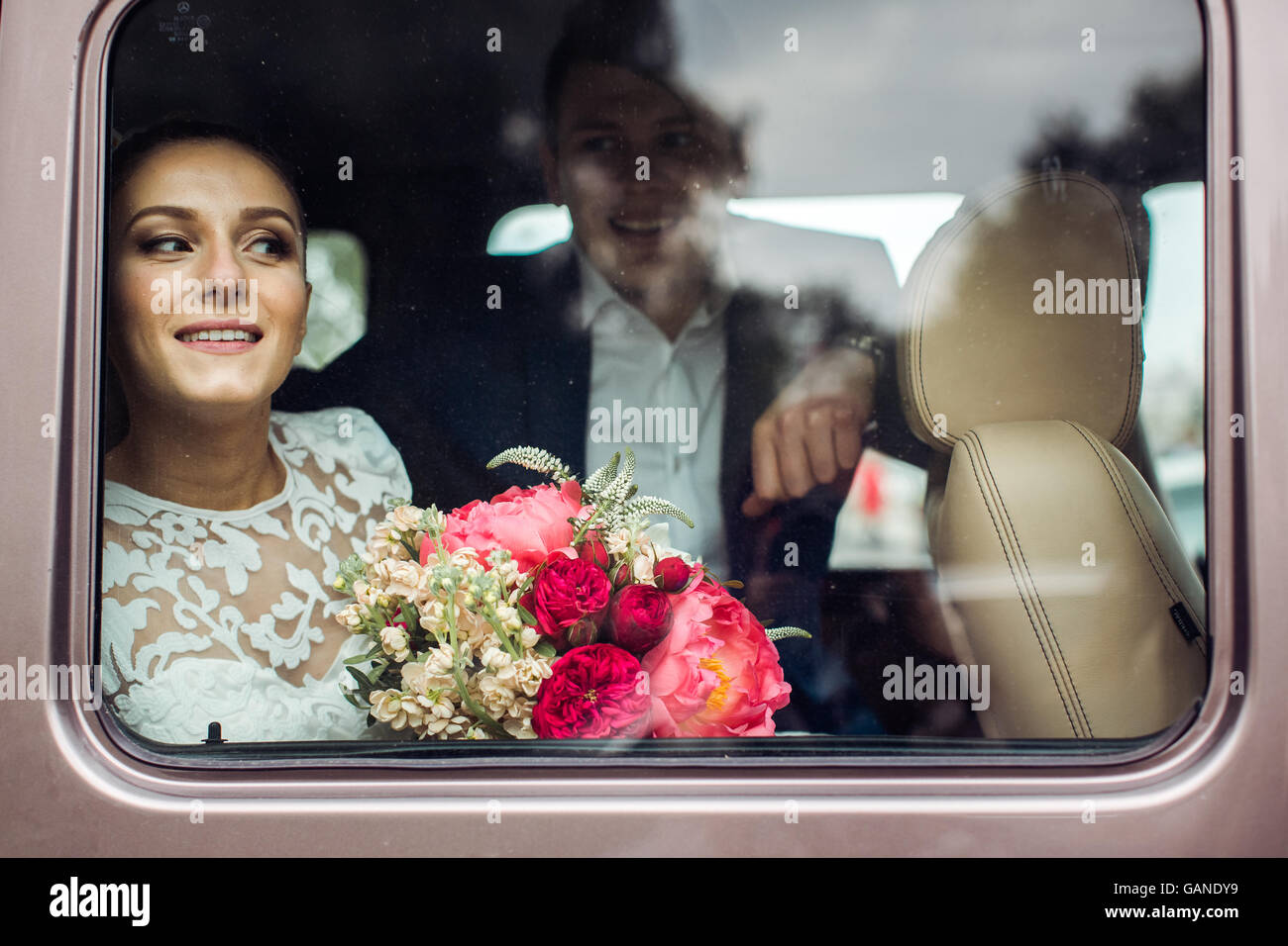 Braut und Bräutigam suchen SUV durch das Autofenster Stockfoto
