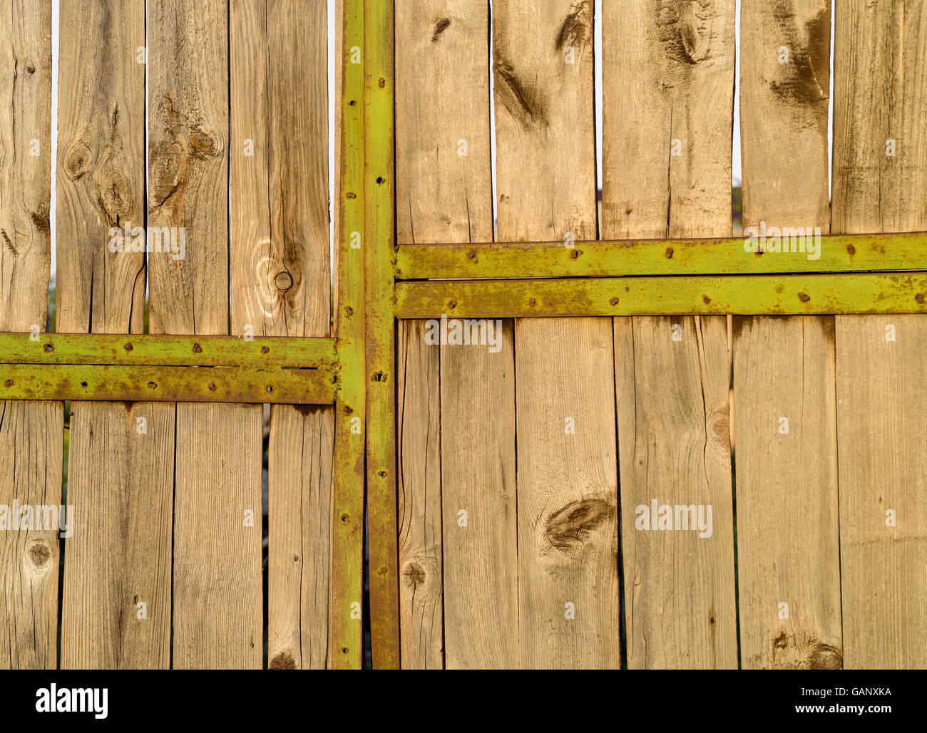 Rustikal und im Alter von grün lackiertem Metall Türrahmen einer Dorf-Garage mit verblassten Holz. Stockfoto