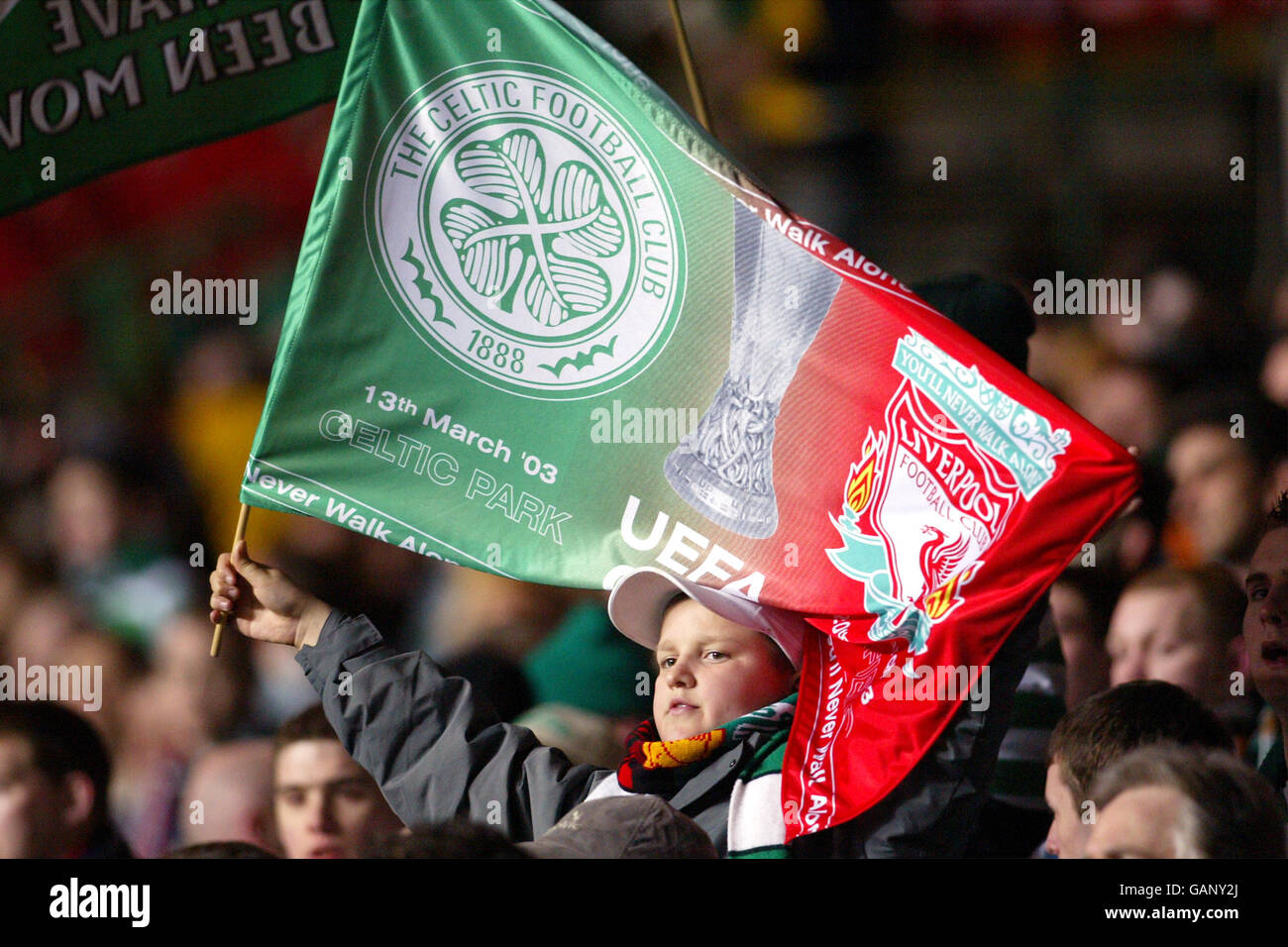 Fußball - UEFA-Cup - Viertelfinale - Erstes Teilstück - Celtic gegen Liverpool. Ein Celtic-Fan lässt sich in den Geist der Dinge eintauchen, bevor er mit einer gespaltenen Celtic- und Liverpool-Flagge startet Stockfoto