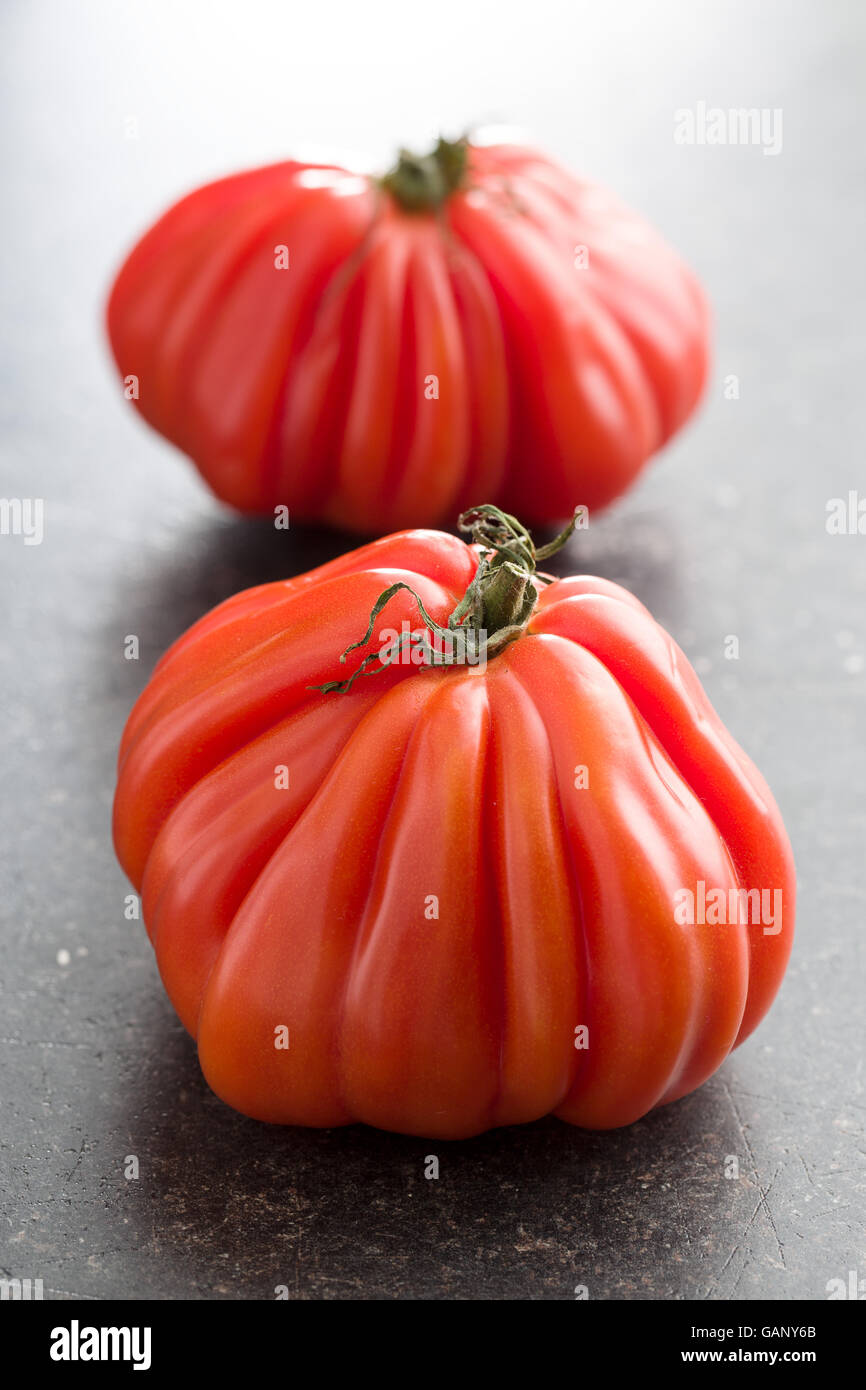 Coeur De Boeuf. Fleischtomaten auf alten Küchentisch. Stockfoto