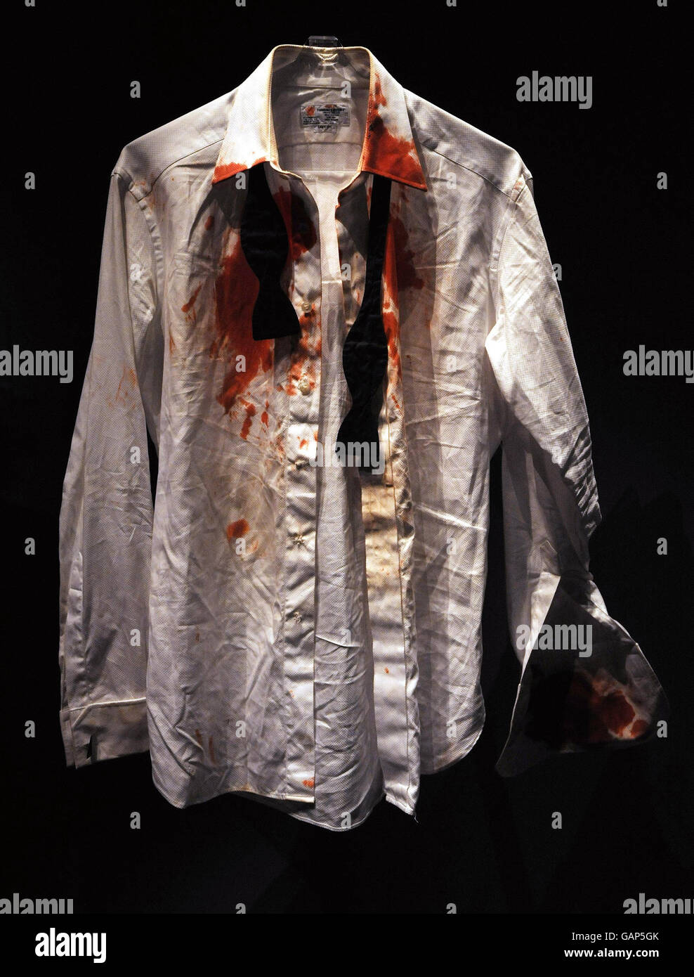 Das blutbefleckte Hemd, das der James Bond-Schauspieler Daniel Craig bei seinem ersten Auftritt als Geheimagent von 007 im Casino Royale trug, auf einer Ausstellung anlässlich des hundertsten Geburtstages des britischen Schriftstellers Ian Fleming, dem Schöpfer von James Bond 007, die von morgen im Imperial war Museum in London eröffnet wurde. Zu sehen sind Erinnerungsstücke und Artefakte aus dem Leben des Autors und der Bond-Filme, darunter Little Nellie, der autogyro von You Only Live Twice, Right, und ein Arbeitsmodell Aston Martin DB5, links, im Besitz von HRH Prinz Andrew. Stockfoto
