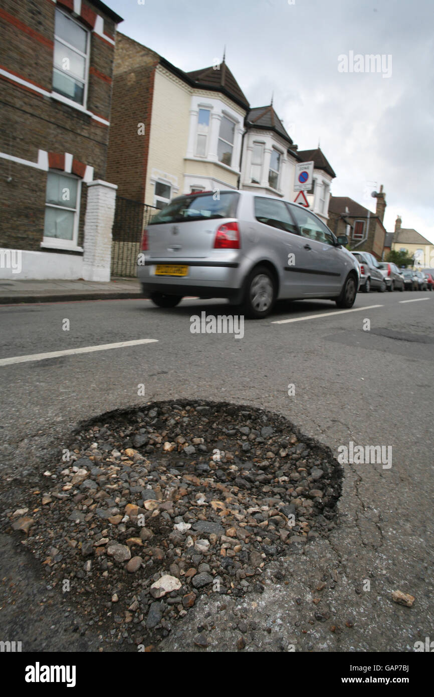 Schlagloch auf der Straße. Ein Schlagloch auf einer Straße in Tooting, SW London. Stockfoto