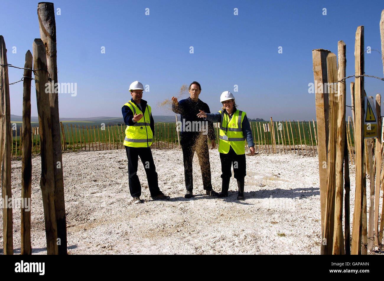 Von links nach rechts, Projektmanager für Skanska Engineering Mark Kirkbride, Projektmanager für englisches Erbe Rob Harding und Inspektorin für antike Denkmäler für englisches Erbe Dr. Amanda Chadburn, sät Gras- und Pflanzensamen während einer Richtungszeremonie auf dem Silbury Hill, Avebury, Wiltshire, um den Erfolg des Projekts zu markieren. Stockfoto