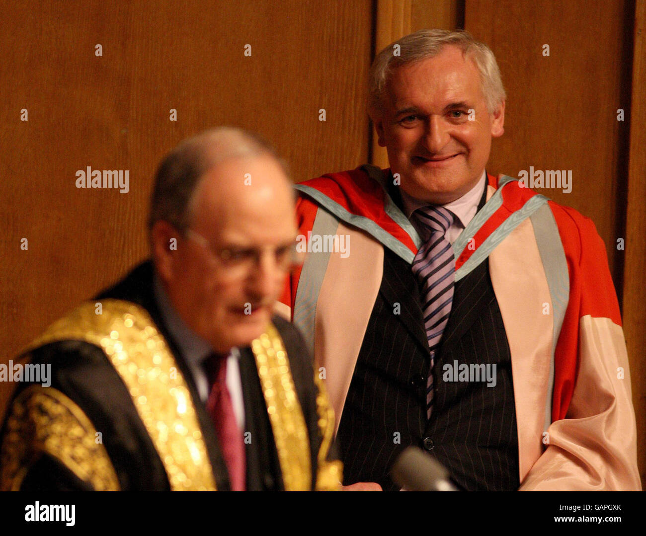 Der kürzlich pensionierte irische Taoiseach Bertie Ahern (rechts) erhält seine Ehrendoktorwürde vom Kanzler der Queen's University, dem ehemaligen US-Senator George Mitchell, in Belfast. Stockfoto