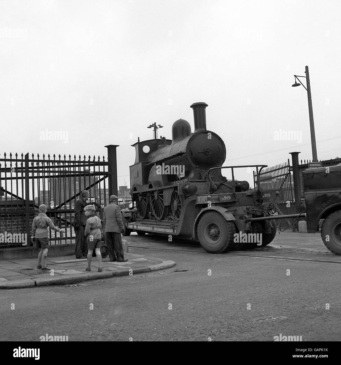 Leider nicht auf eigene Faust, sondern auf einem Straßenanhänger sitzend, wird 'Jumbo', die letzte einer Linie von 130 2-4-D-Lokomotiven der Präzedenzklasse, vom Bahnbetriebswerk der Nine Elms Lane auf dem Weg zum britischen Transportmuseum in Clapham gebracht. Stockfoto