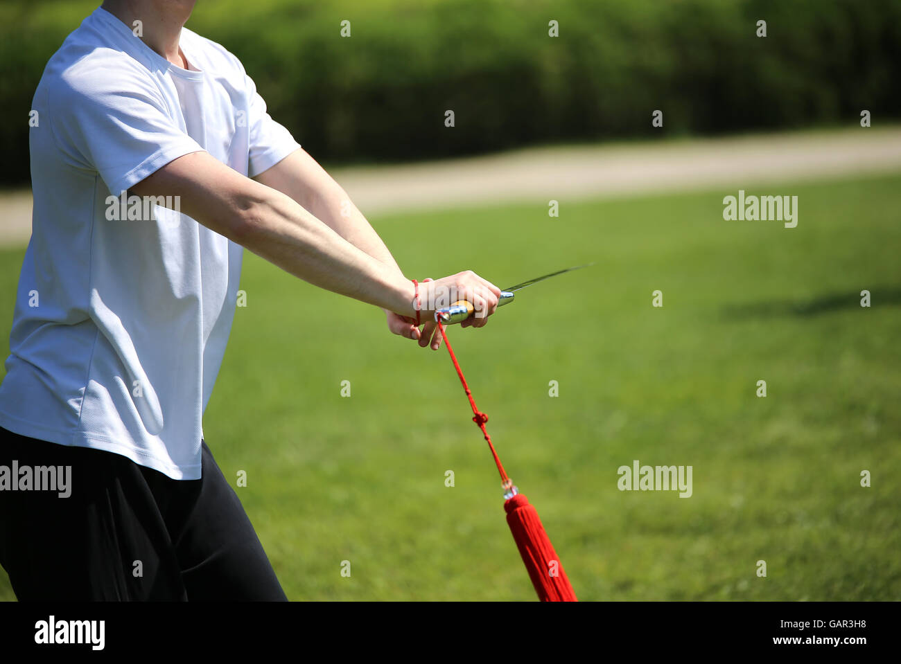 Tai Chi Kampfkunst Sportler Experte macht Bewegungen mit scharfen Schwert Stockfoto