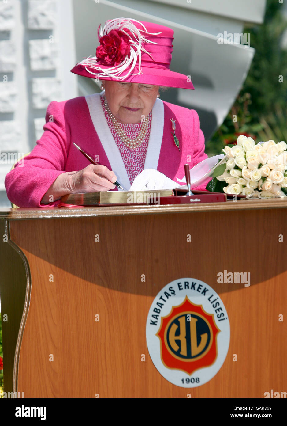 Die britische Königin Elizabeth II. Unterschreibt am dritten Tag ihres Besuches der Königlichen Hoheiten in der Republik Türkei das Besucherbuch an der Kabatas-Schule in Istanbul. Stockfoto