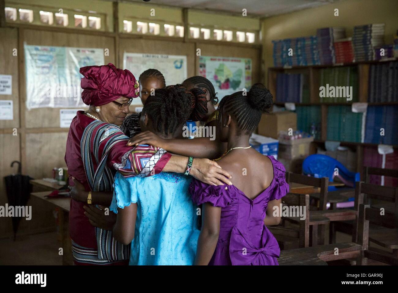 Liberianische Präsidentin Ellen Johnson Sirleaf schmiegt sich an Studenten vor einer Diskussionsrunde lassen Mädchen lernen an R.S. Caulfield Senior High School 27. Juni 2016 in Vereinigung Stadt Liberia. Sirleaf stiess US First Lady Michelle Obama in der Diskussion. Stockfoto