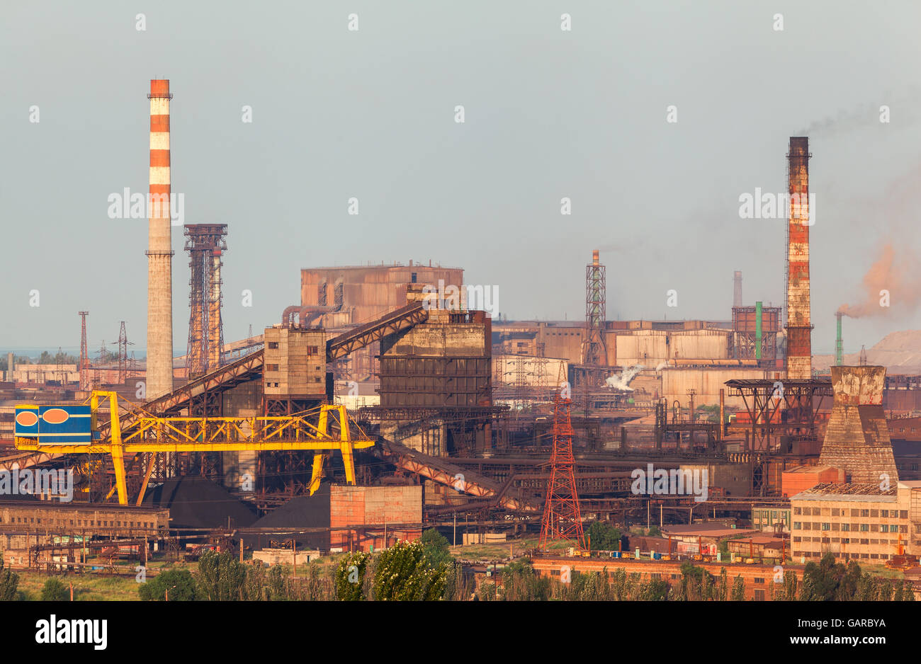 Stahlwerk mit Schornsteinen bei Sonnenuntergang. metallurgische Fabrik. Stahlwerke, Eisenhütte. Schwerindustrie in Europa. Luft-Verunreinigung-f Stockfoto